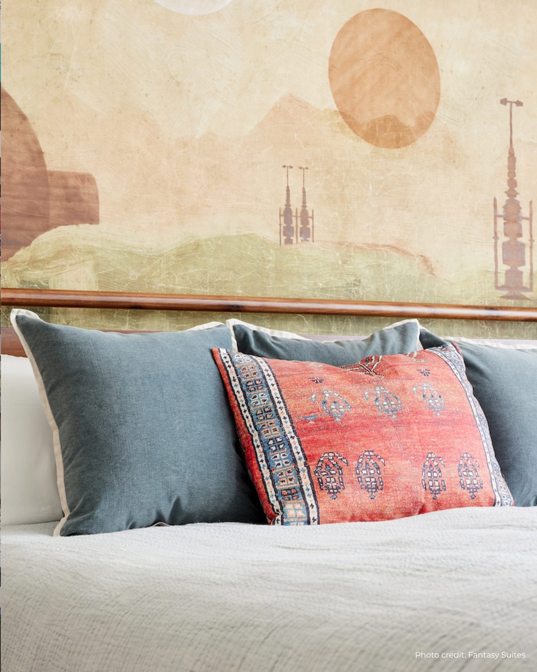 Decorative pillows on a sofa with a scenic wall mural in the background